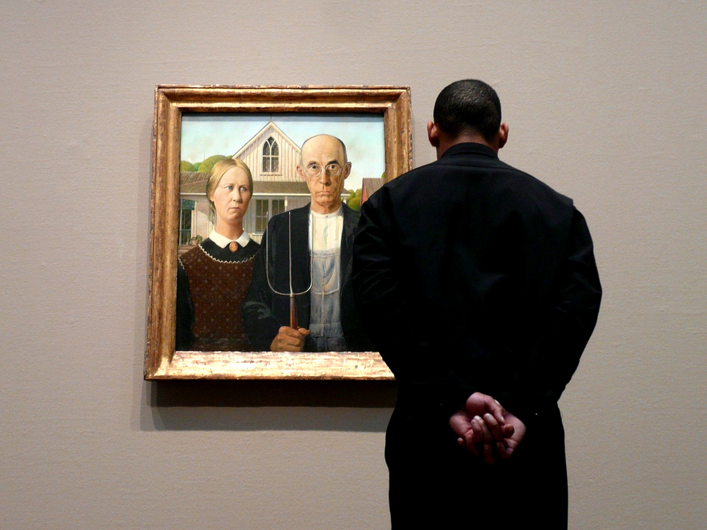 What do you see? Man looking at Grant Wood's "American Gothic" painting