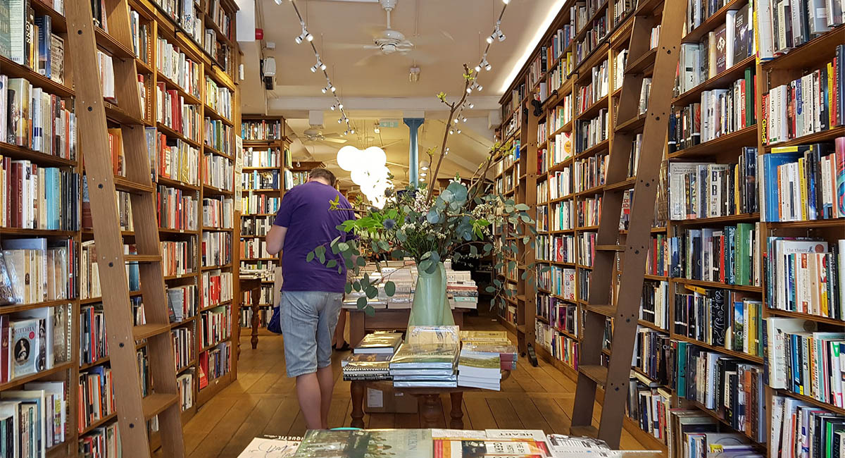 man in bookshop with ladders
