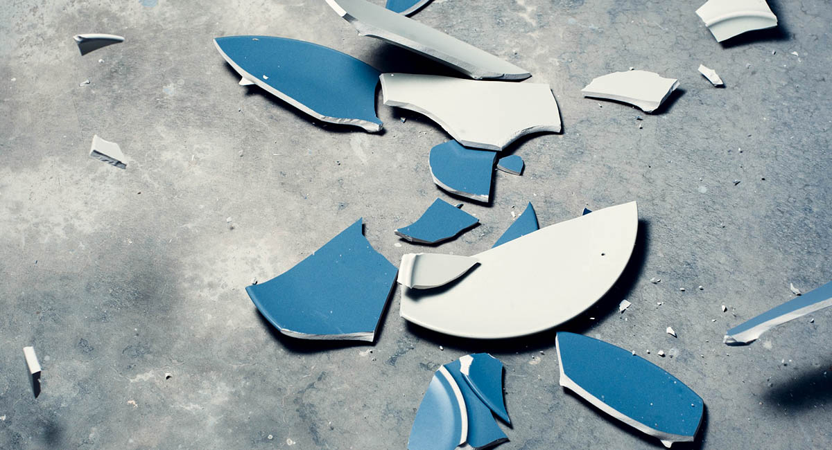 Blue and white plates broken on a cement floor