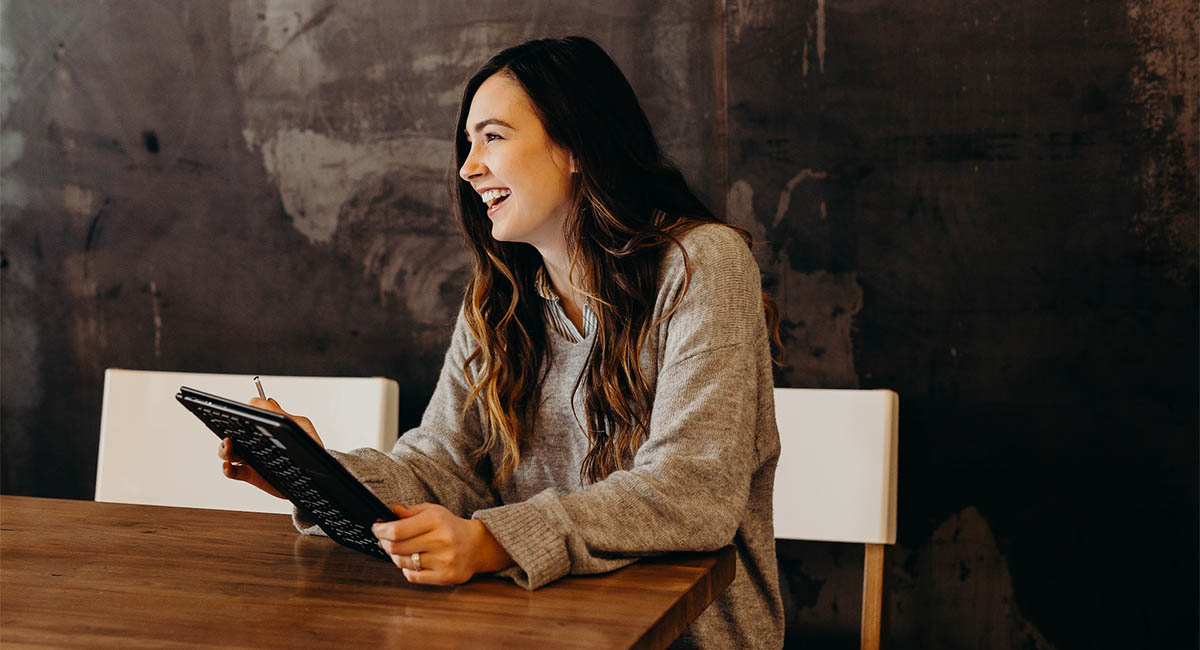 Smiling woman at table with laptop