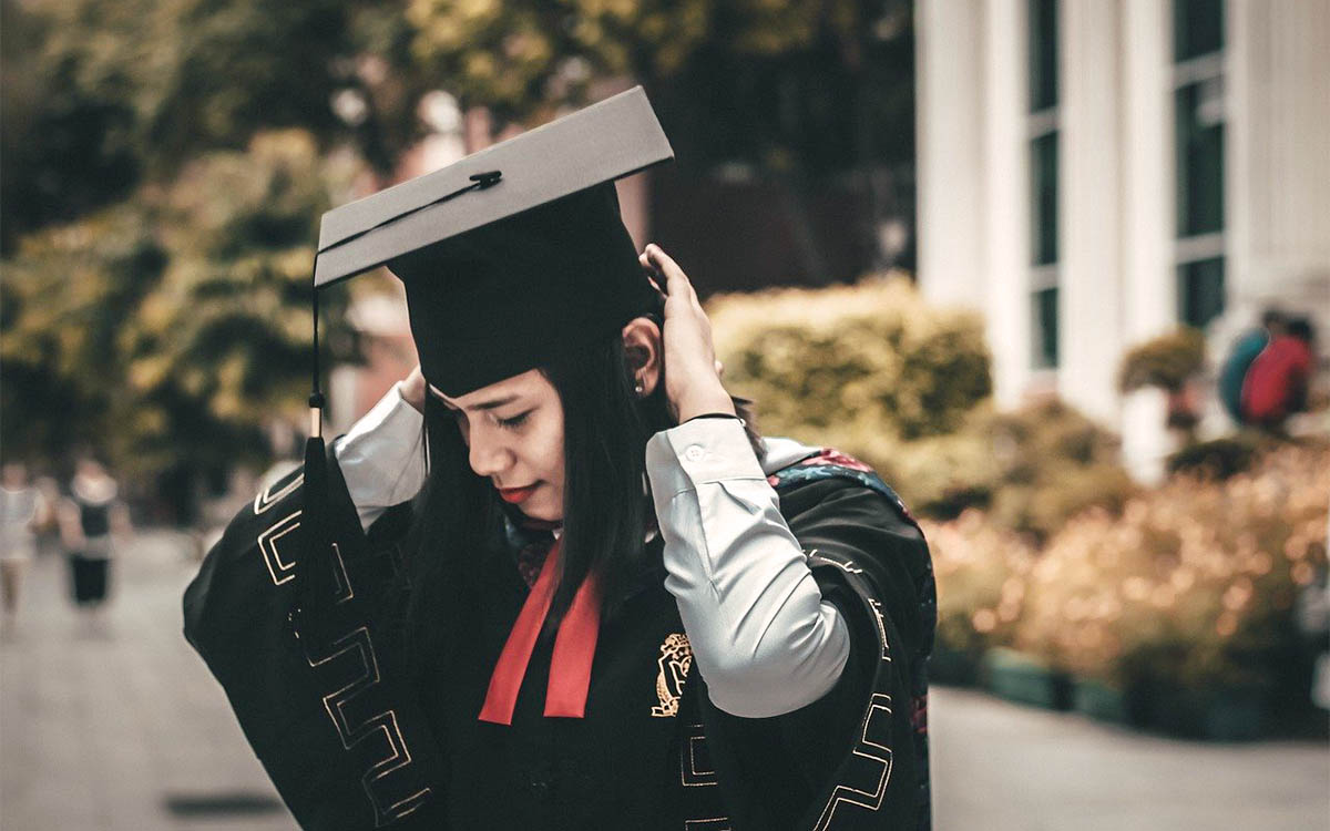 What did you study? Young woman wearing graduation gown and mortar board