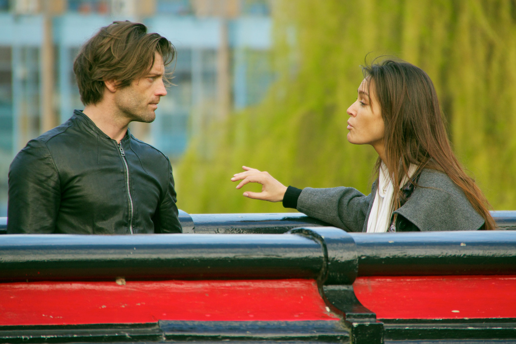 What are they saying? A man and woman talking on a bench