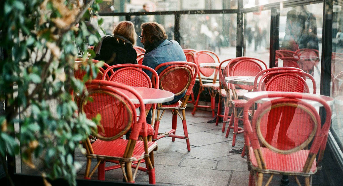Man and woman in cafe with red chairs