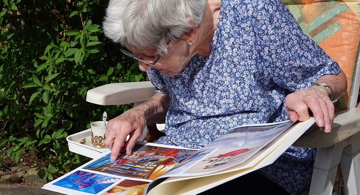 Elderly woman looking at photo album