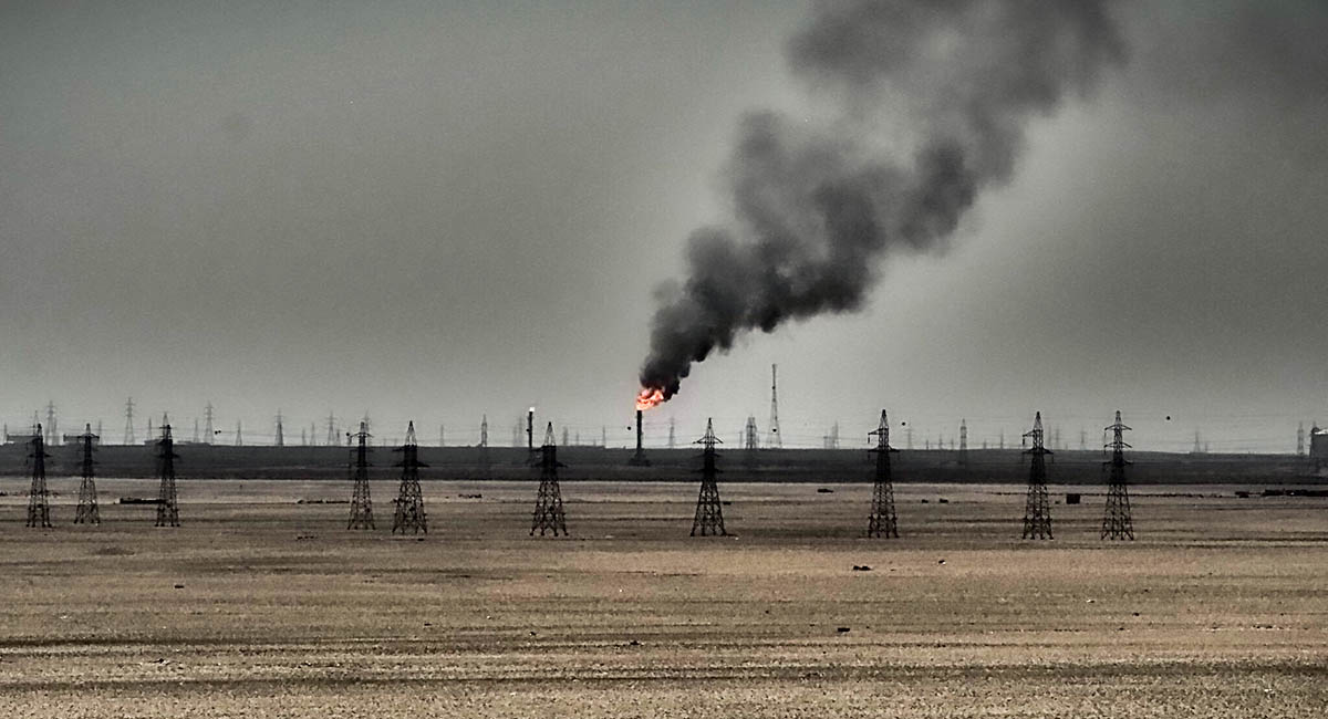 oil field with flames and smoke in the distance