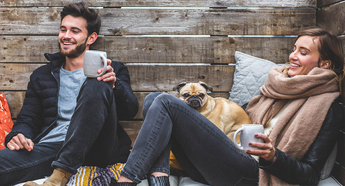 young people with small dog in coffee shop