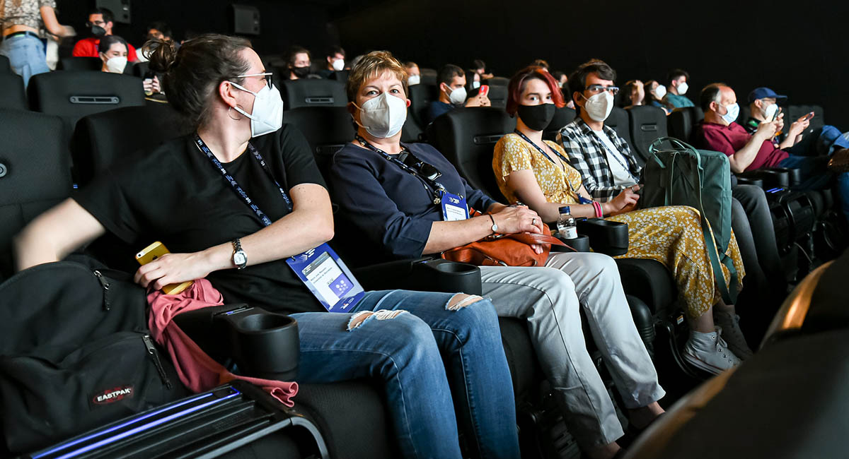 People in a movie theater wearing protective masks