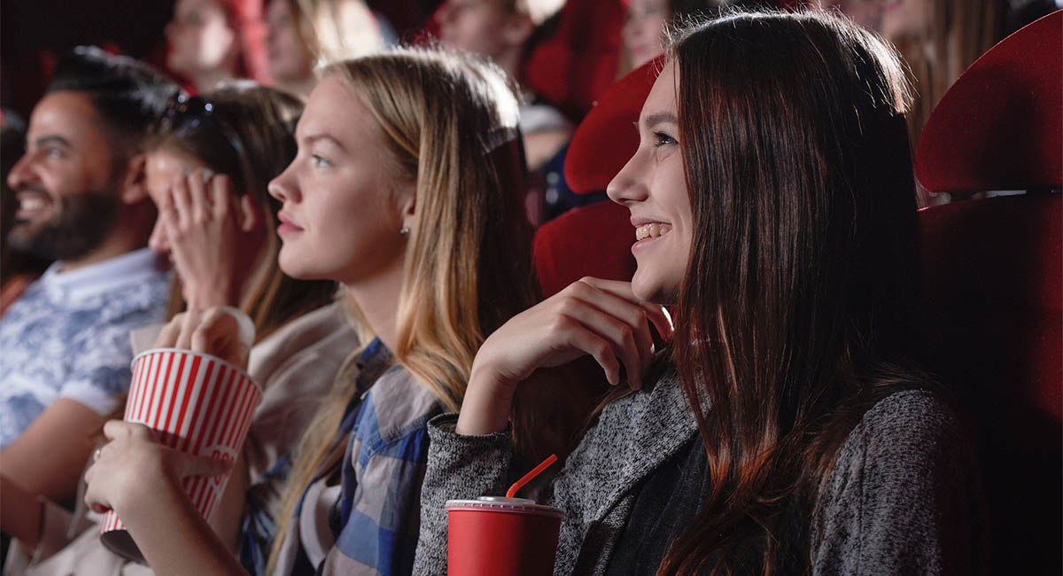 Young women watching a movie in a theater, Caucasian