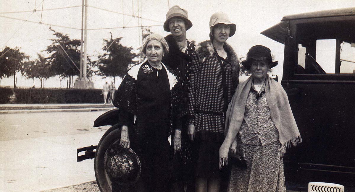 Four women standing by an automobile  in the 1920s