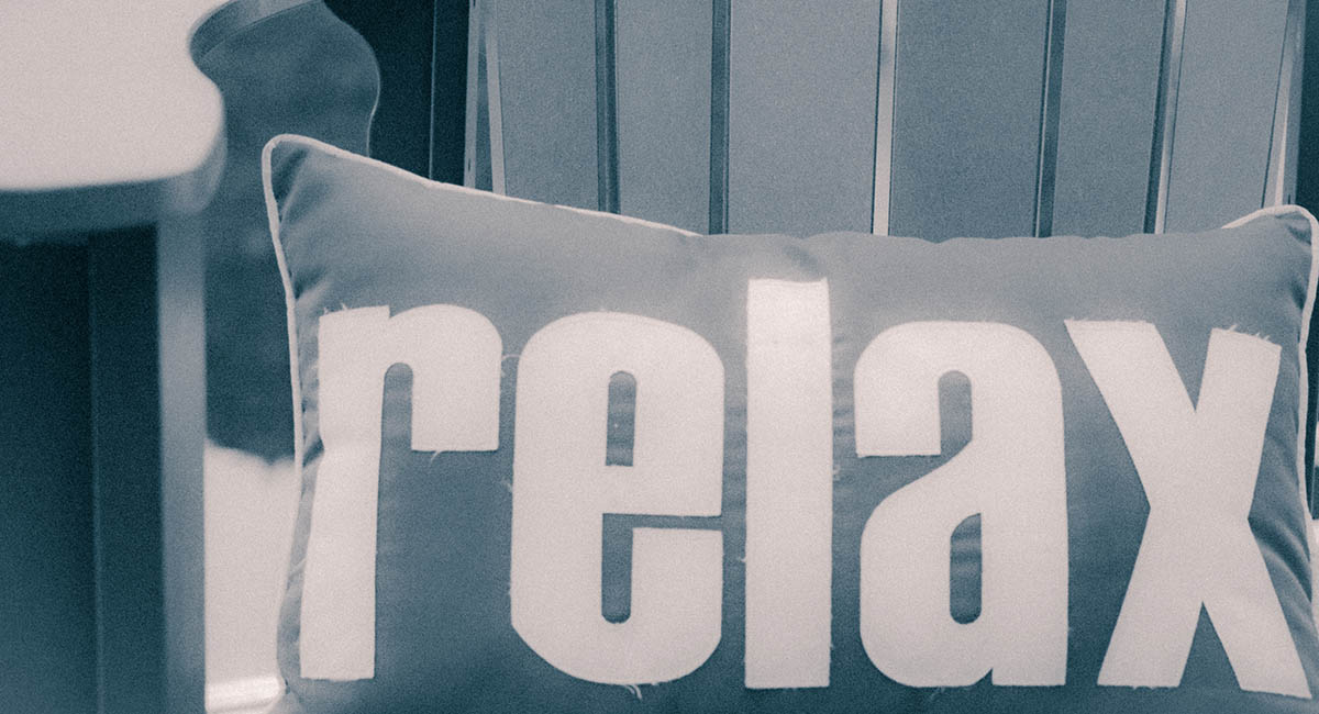 Pillow on deck chair with word RELAX, monotone cyan