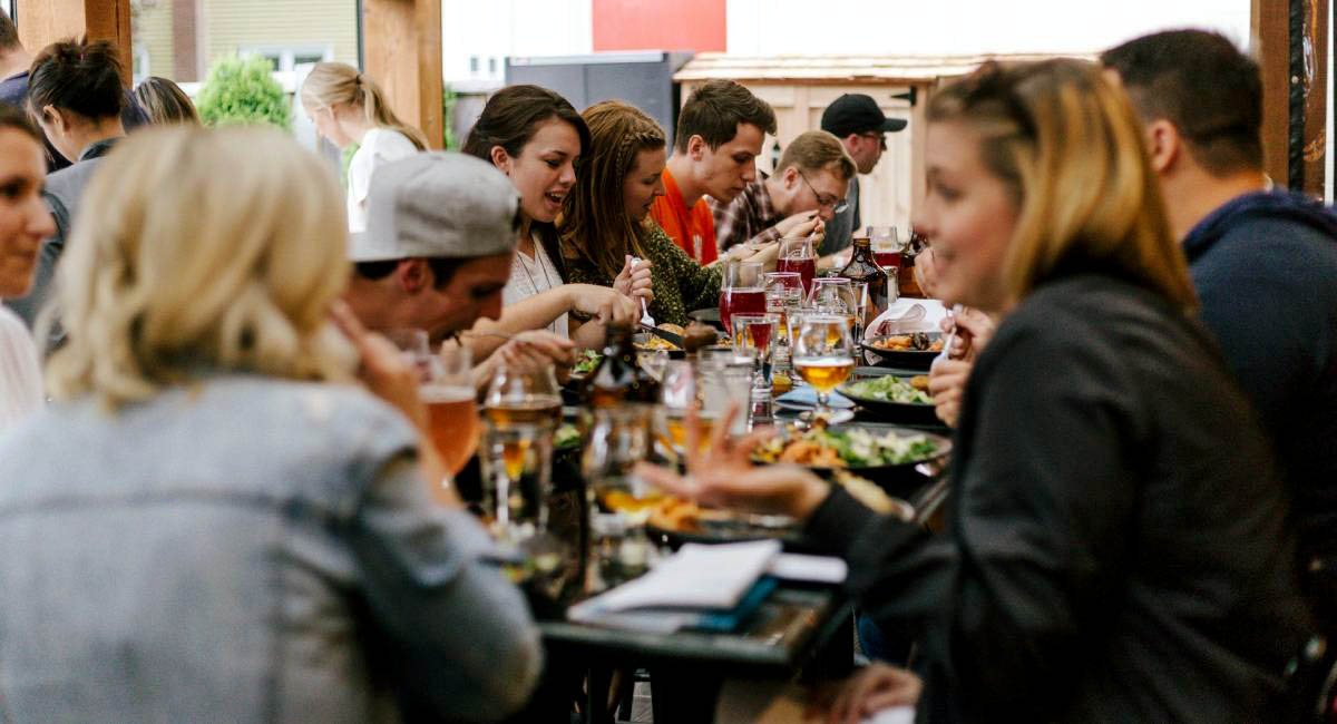 My favorite restaurant! People eating at a long table in a restaurant
