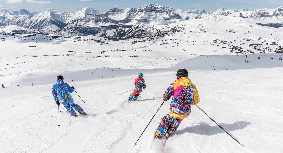 People in colorful suits skiing in the mountains