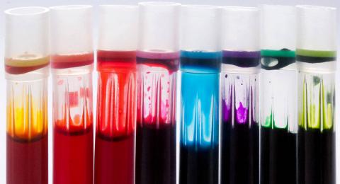 eight different colors of liquid in test tubes