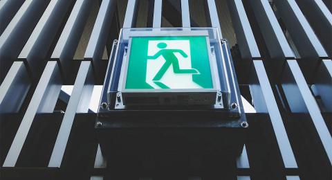 green exit sign with human stick figure going out through door