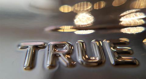 The word "true" in embellished letters on gold