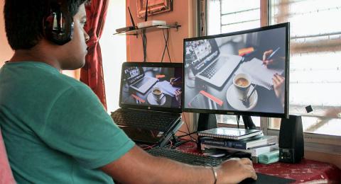 man at dual monitors with headphones