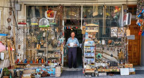 Old man standing in door of junk shop