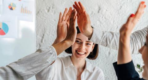 young business woman giving high-fives to colleagues