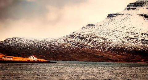 Isolated house on the shore by a mountain, Iceland
