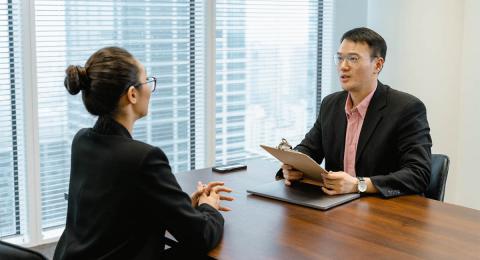 woman and man sitting across table, job interview