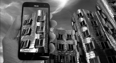 monochrome mobile phone screen with architecture also seen behind it
