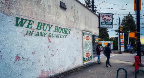 Exterior of used bookstore with two people walking by
