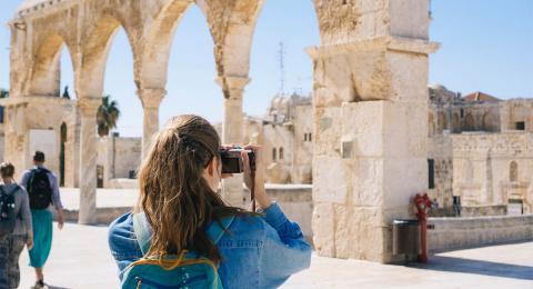 Woman tourist taking a photo of ancient ruins