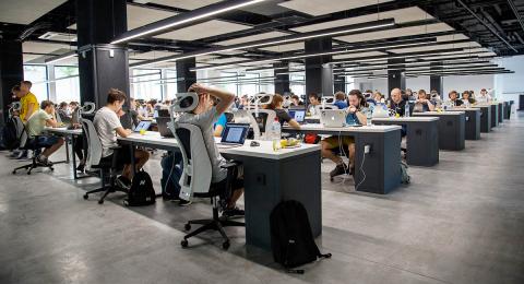 Large office with people working at rows of desks