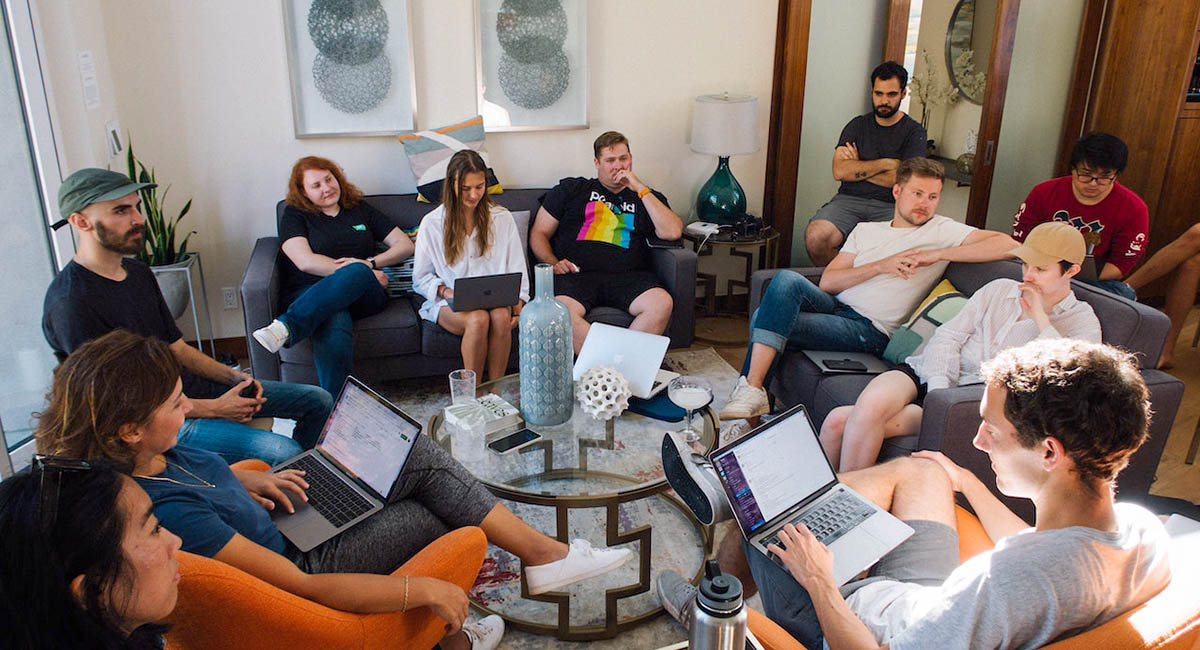 group sitting in living room with laptops