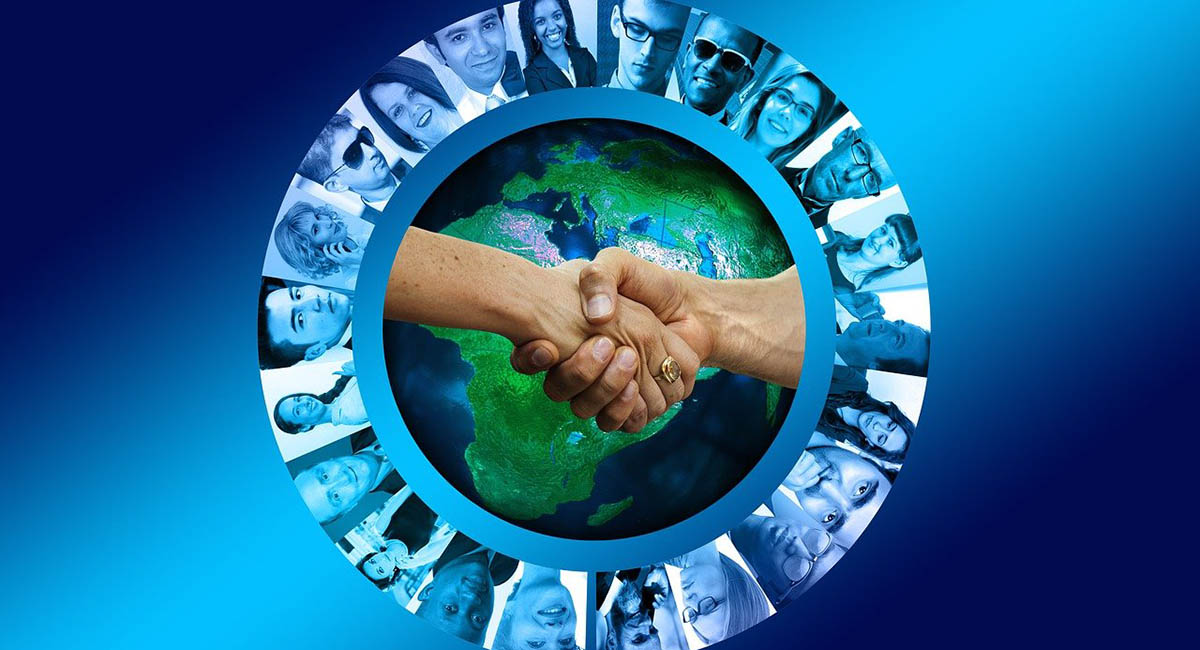 two hands shaking hands with globe and images of people's heads surrounding it; blue