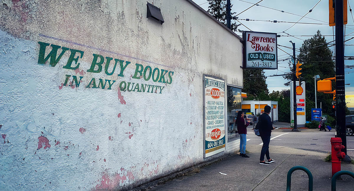 Exterior of used bookstore with two people walking by